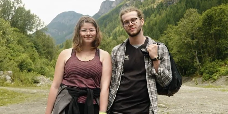 Man and Women standing in a forest smiling