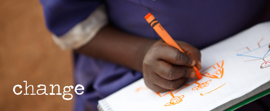 African student writing on paper with orange crayon. Photo credit: Jacquie Labatt