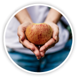 Circle image with someone holding an apple in their hands